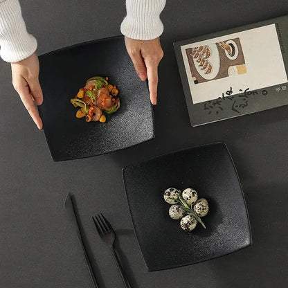 Black matte 7.5 inch square ceramic dining plate with a speckled finish by decorbites