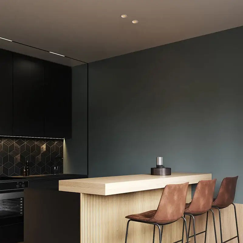 A sleek black countertop with modern geometric tile backsplash illuminated by decorbites™ recessed led downlight ceiling spot