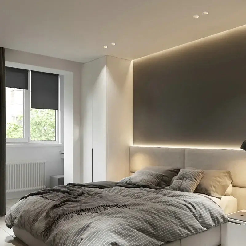 Modern beige upholstered bed with striped gray and white duvet shown under decorbites™ recessed led downlight ceiling spot