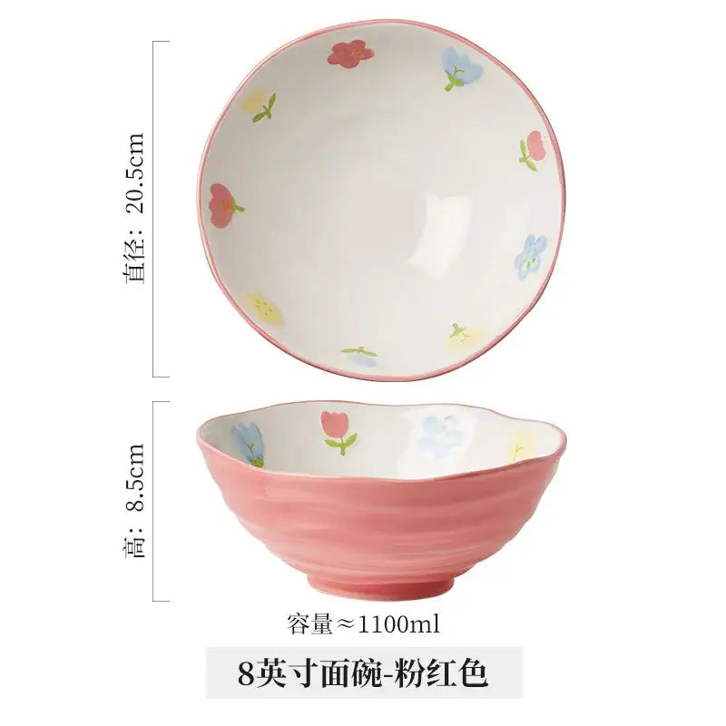 A pink ceramic ramen bowl by decorbites with scalloped rim and hand-painted floral patterns in red blue and yellow