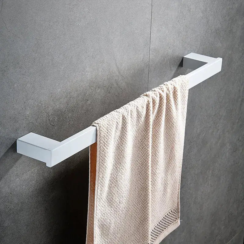 White rectangular towel rack holding beige textured towel with mesh hem from decorbites bathroom hardware set
