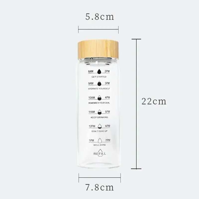 Clear glass water bottle with bamboo lid and measurement markings for hydration tracking from DecorBites™