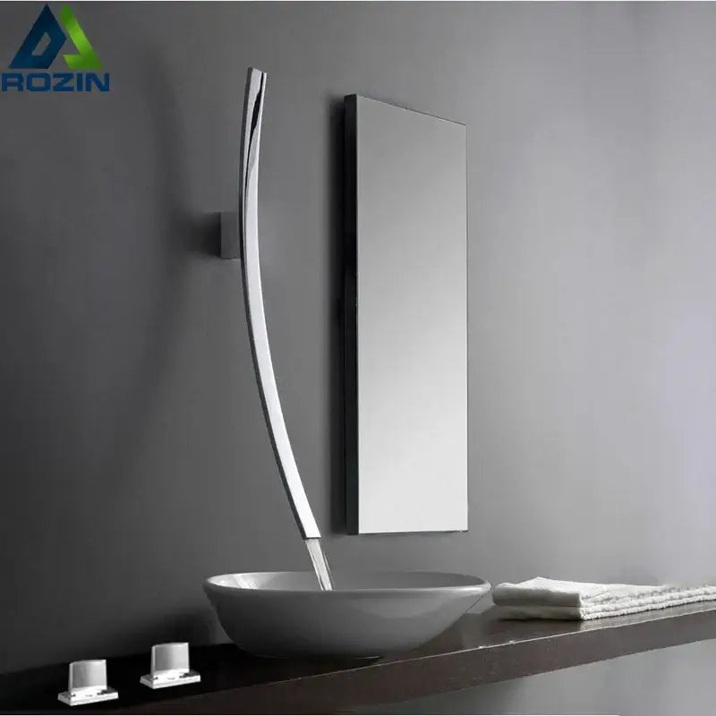 Modern chrome-finished basin mixer tap with sleek curved design wall mounted beside mirror above white vessel sink