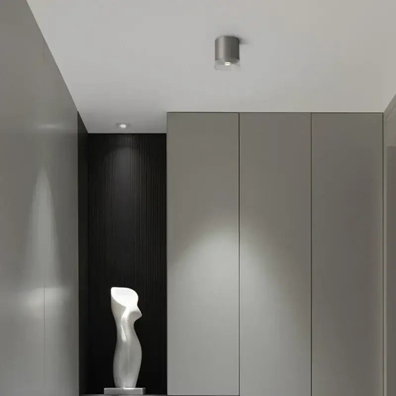 A sleek white abstract sculpture with glossy curves near a nickel decorbites 7w high cri 97 led downlight for living room