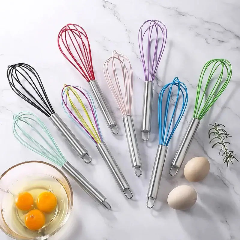 Set of colorful stainless steel silicone whisk mixers with 8-inch handles arranged on marble for baking and cooking