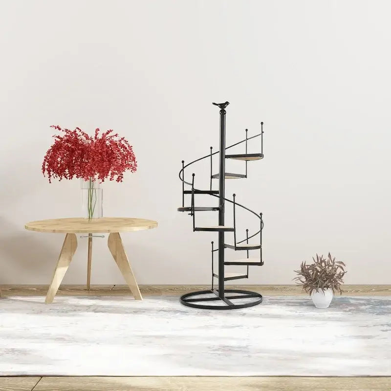 Black metal spiral plant stand with circular base and bird finial featuring stair shape and wood plate layers by DecorBites