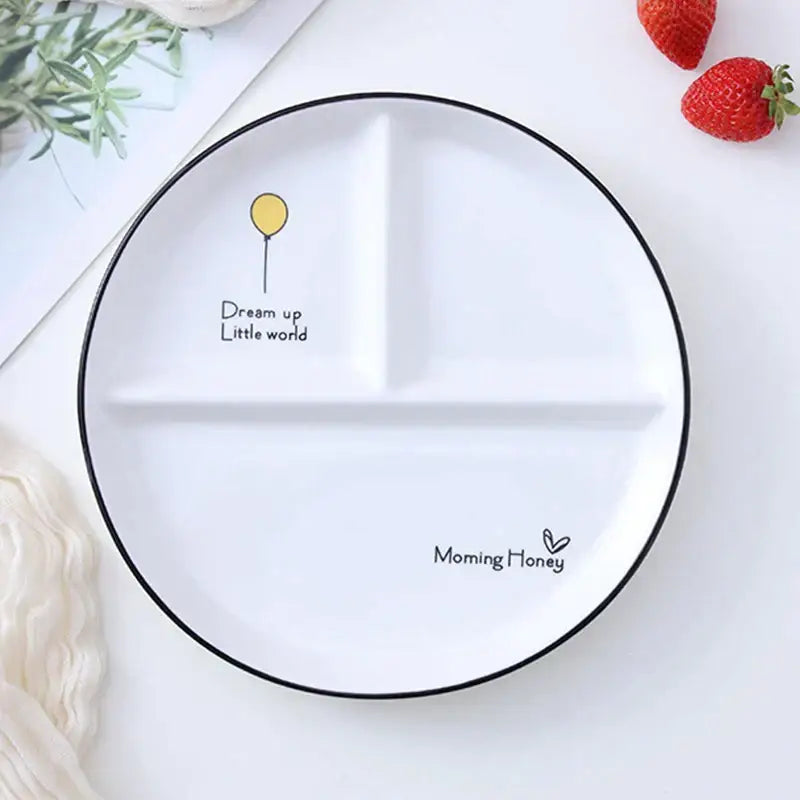 White ceramic round grid plate with black rim three compartments featuring balloon illustration and motivational text