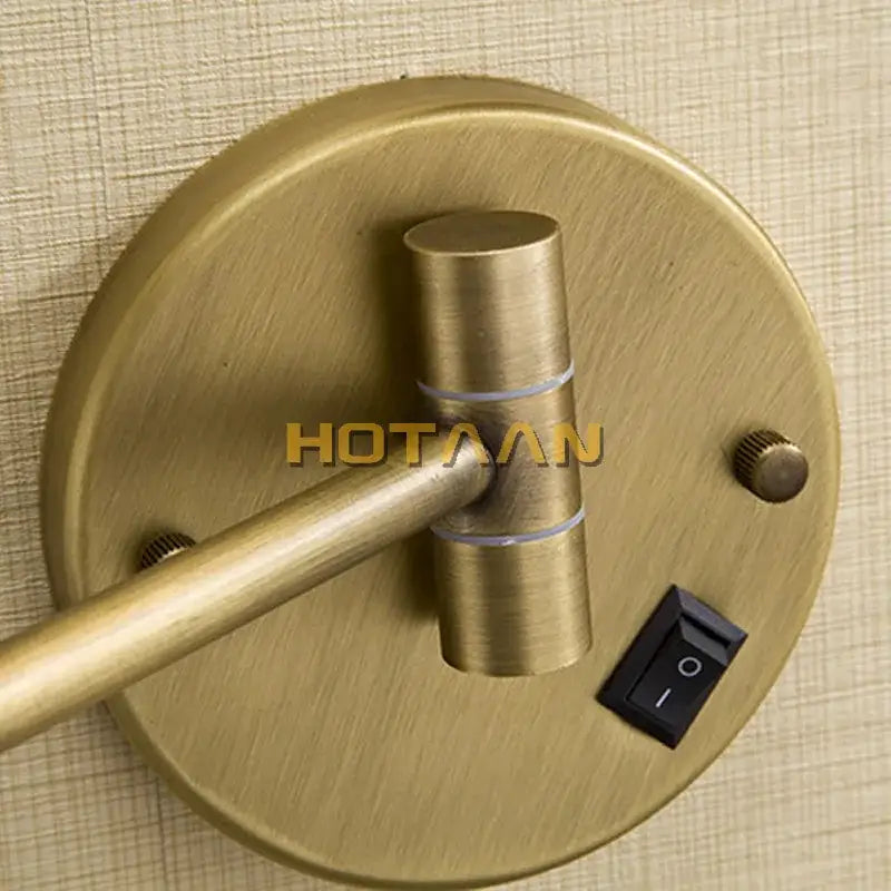 Antique brass-finished wall-mounted reading lamp with adjustable arm and black switch next to decorbites™ round led light makeup mirror