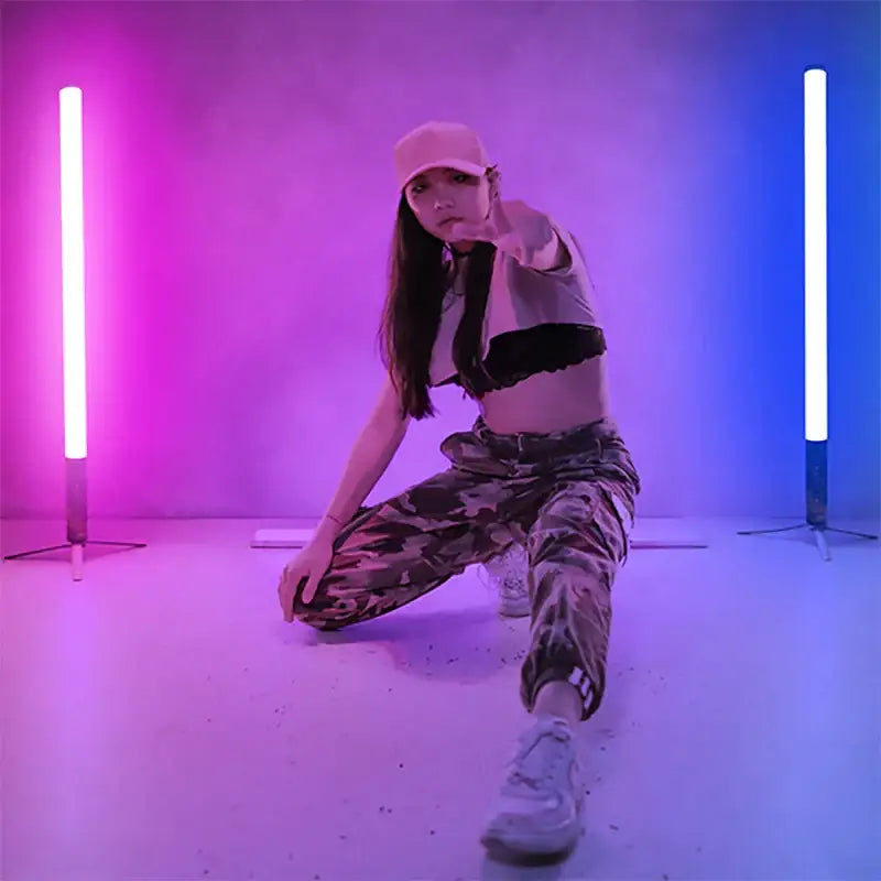 A woman poses with DecorBites™ 85cm neon pink and blue color-changing mood lighting sticks with music mode