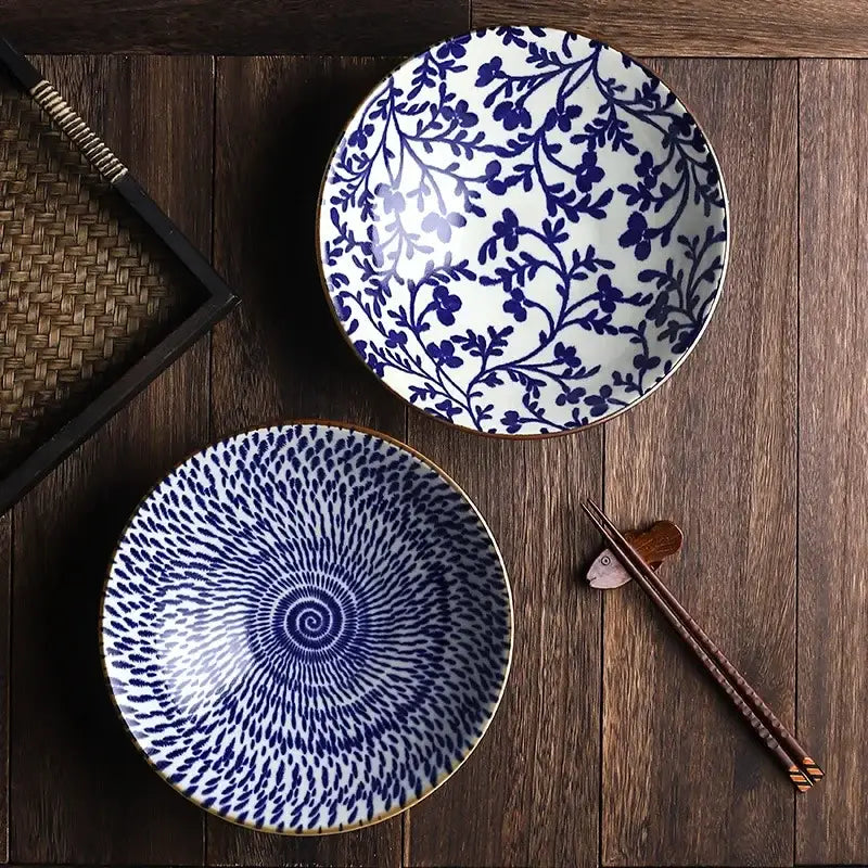 Two ceramic japanese ramen bowls with blue and white patterns and gold rims for soup salad or rice