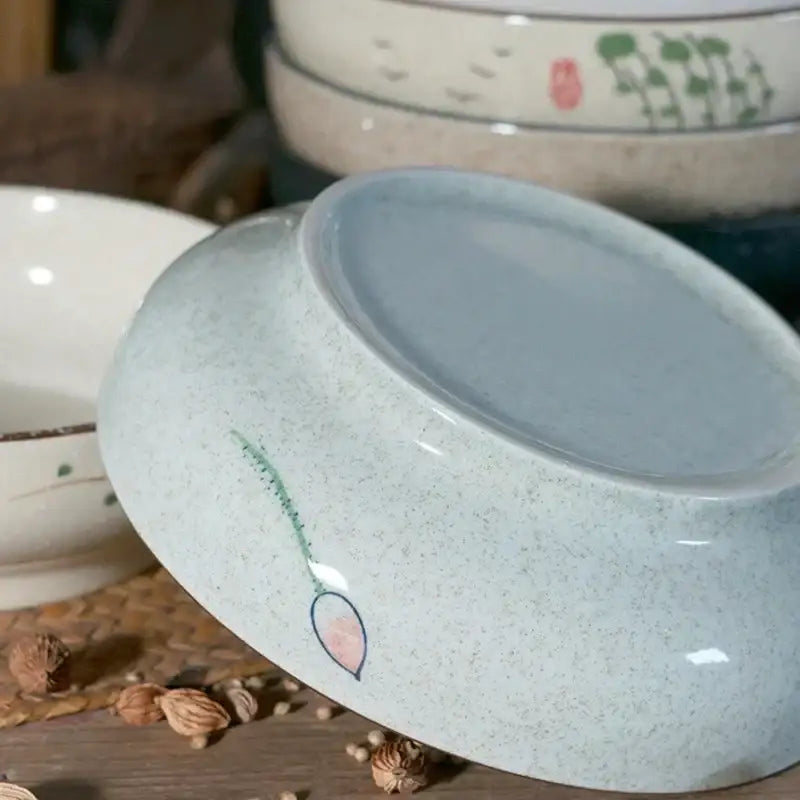 A light blue retro ceramic ramen noodle bowl with speckled texture and pink lotus illustration for soup serving