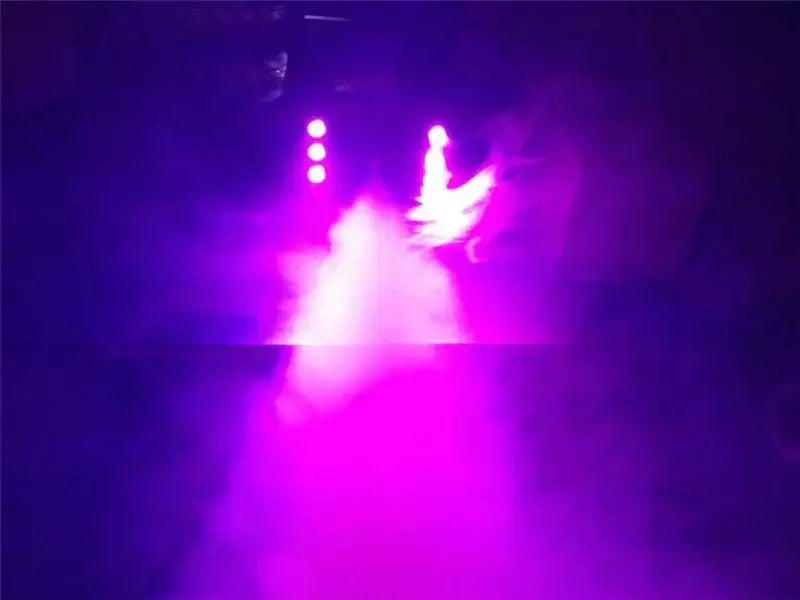 A glowing purple stage light highlights a performer amid fog created by the decorbites 900w fog machine for events