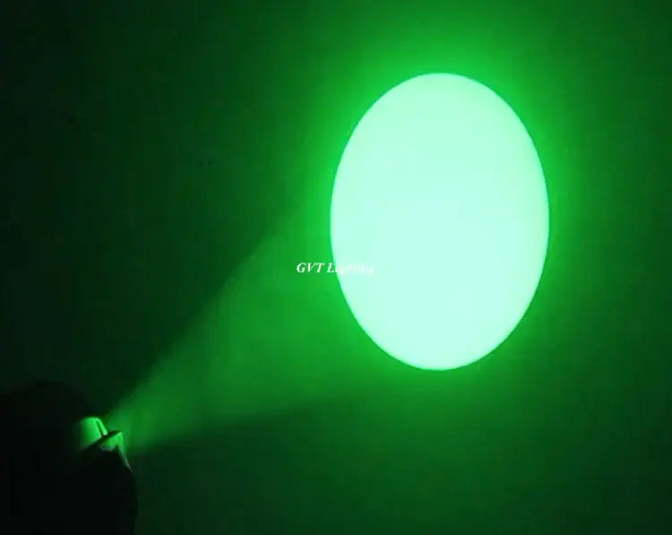 A bright green circular spotlight beam from the DecorBites™ 90w led spot moving head illuminates a dark surface