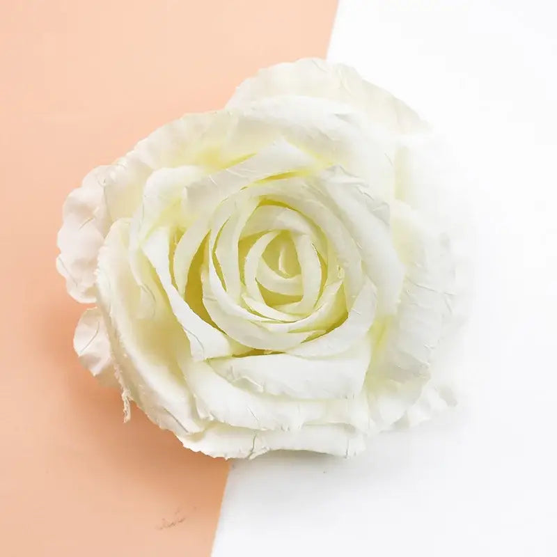 A delicate white 9cm silk rose with softly layered petals and a subtle yellowish center from decorbites artificial flowers