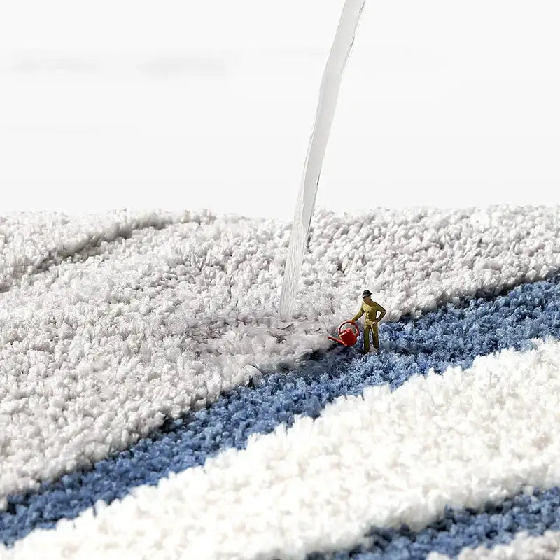 A miniature gardener on a plush white and blue striped decorbites absorbent water bathroom mat rug