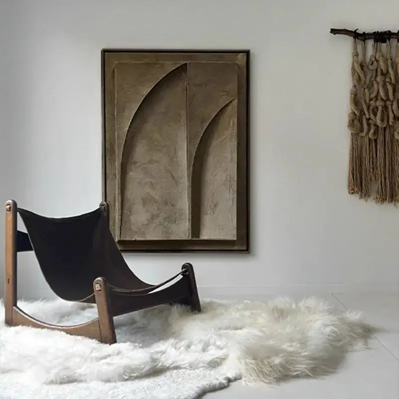 Mid-century modern wooden-framed hammock chair with black leather sling displayed alongside abstract 3d geometry canvas prints