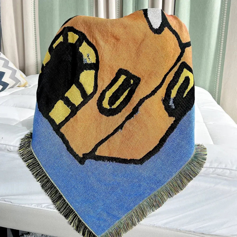 A decorbites abstract aesthetic triangular knit sofa blanket with a bold cartoon face on orange and blue edges