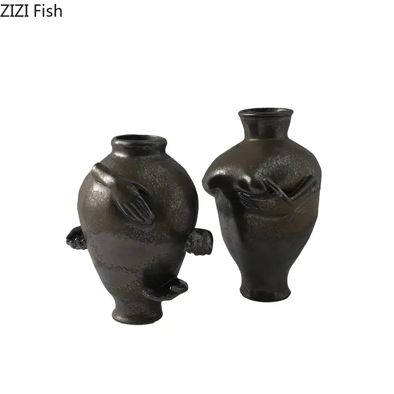 Two dark matte-finished decorbites abstract art ceramic vases with sculpted hand and foot details for room decoration