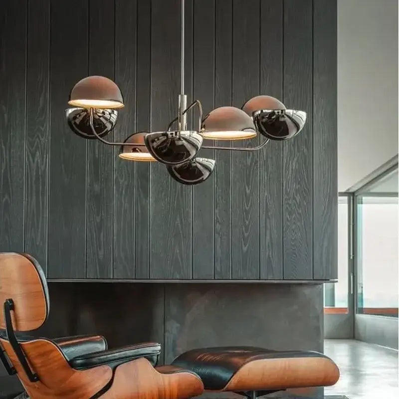 Modern decorbites abstract art chandelier with five polished chrome dome shades above wooden leather chair