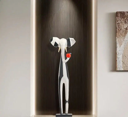 A decorbites abstract art living room tv cabinet featuring a sleek geometric elephant sculpture holding a red apple