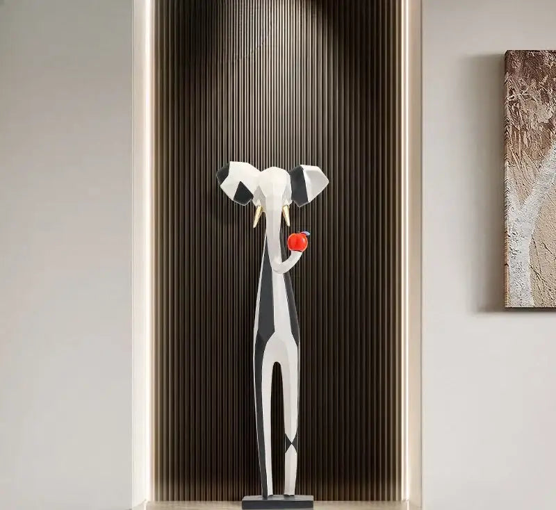 A decorbites abstract art living room tv cabinet featuring a sleek geometric elephant sculpture holding a red apple