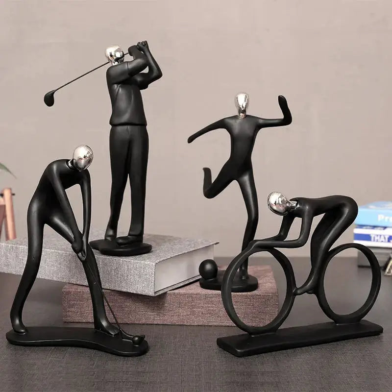 Set of four black resin abstract athlete statue sculptures with silver heads depicting golfer dancer cyclist and archer by DecorBites