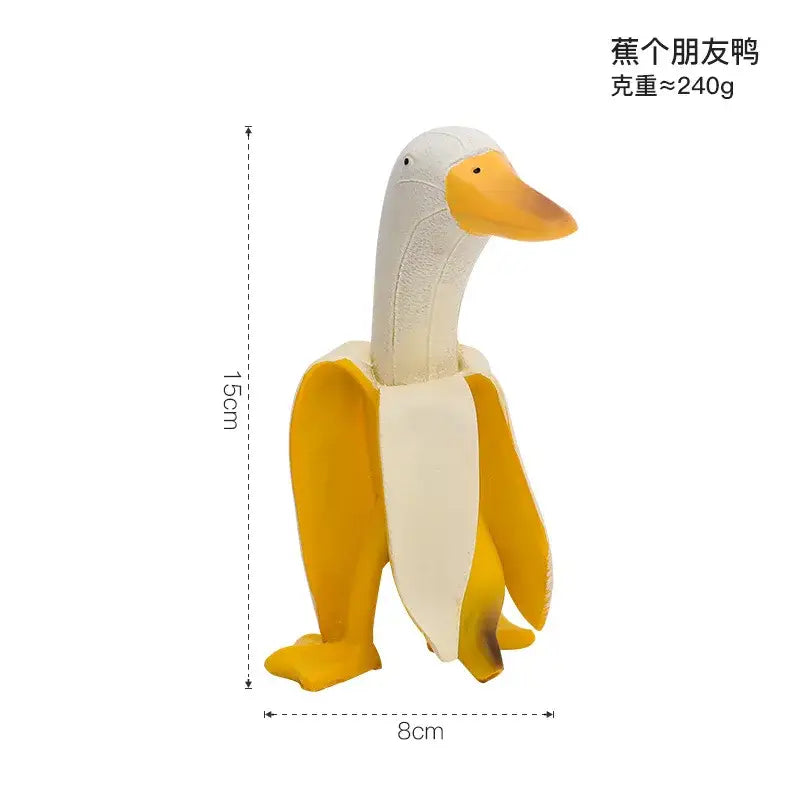 A plush yellow beak and feet decorative figurine of an abstract banana duck sculpture emerging from a peeled banana peel