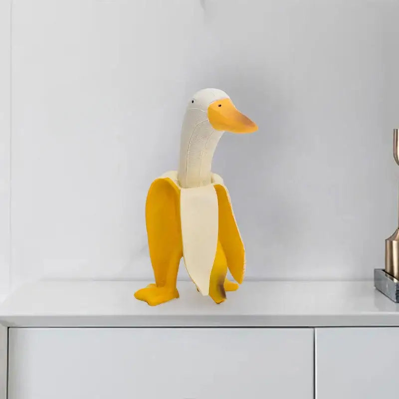 Whimsical white and yellow decorative figurine abstract banana duck sculpture made of smooth plastic for home decor