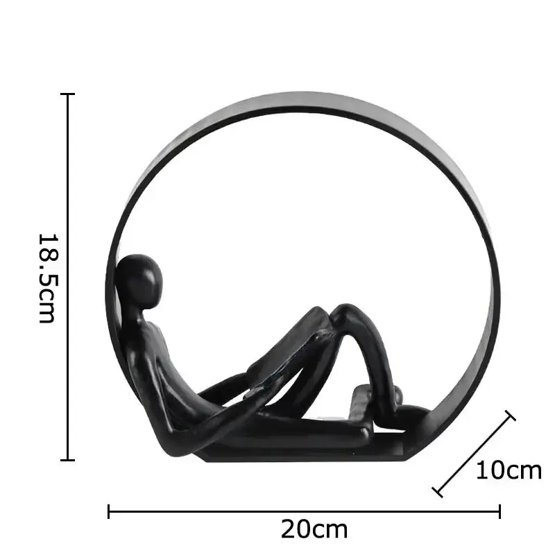 Black glossy resin figurine of abstract black characters reclining within a circular frame for aesthetic room decor