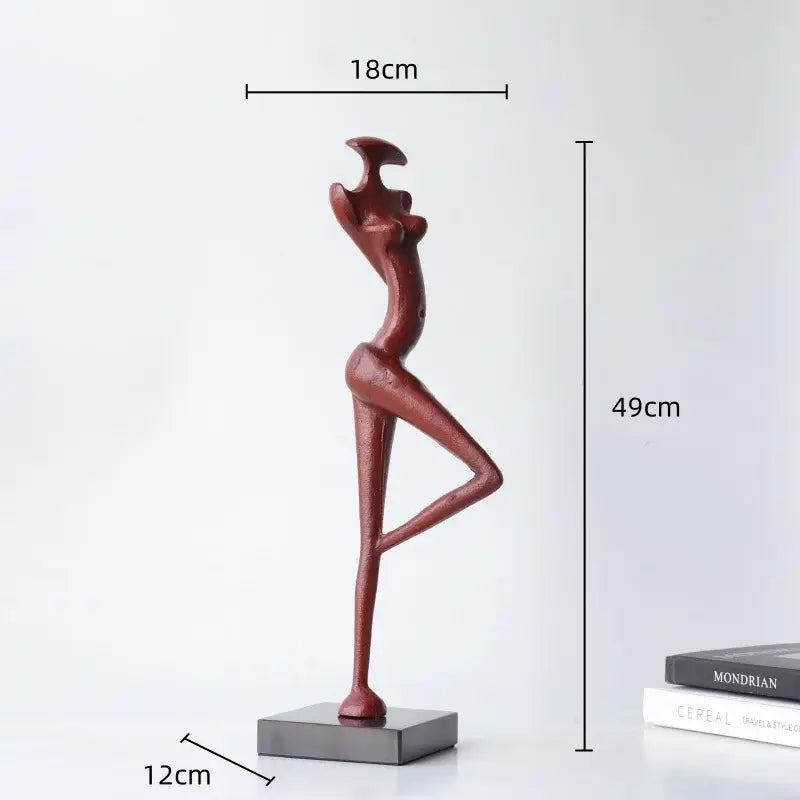 A decorbites abstract black metal female figure sculpture in red with elongated limbs on a dark gray base for home decor
