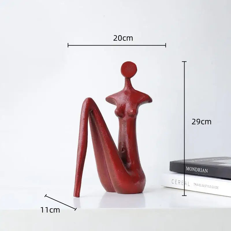 Decorbites abstract black metal female figure sculpture featuring a sleek glossy red seated design with elongated legs