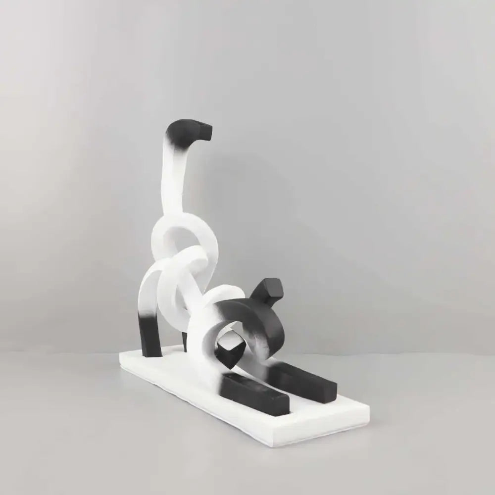 Decorbites abstract cat sculpture in black and white resin with flowing forms on rectangular base for children’s decor