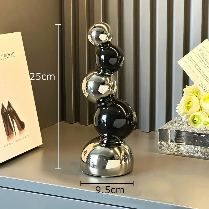 Decorbites abstract ceramic sculpture ornament featuring glossy black and metallic silver spheres on a reflective base