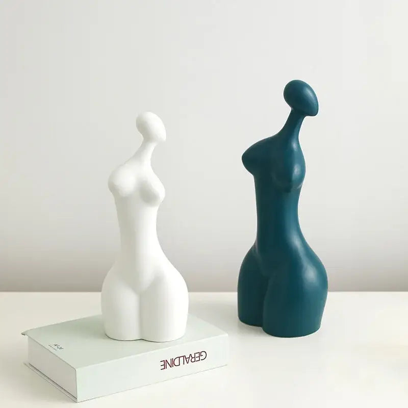 Two minimalist DecorBites abstract ceramic sexy woman statues in white and teal with smooth, stylized forms