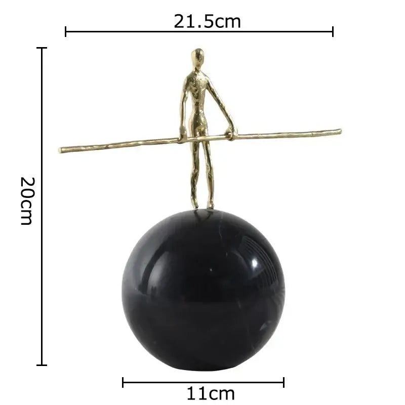 A sleek gold-toned abstract character marble sculpture by DecorBites™ on a black marble sphere for room decor