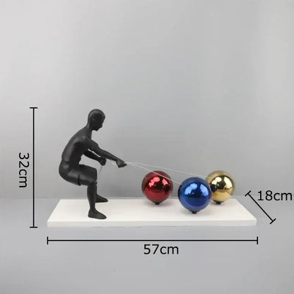 Black metal sculpture figurine pulling red blue and gold glossy spheres decorbites abstract character desk ornament