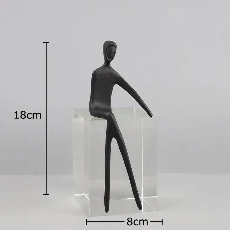 DecorBites abstract character sculpture featuring a black figurine with elongated limbs on a crystal base for modern decor
