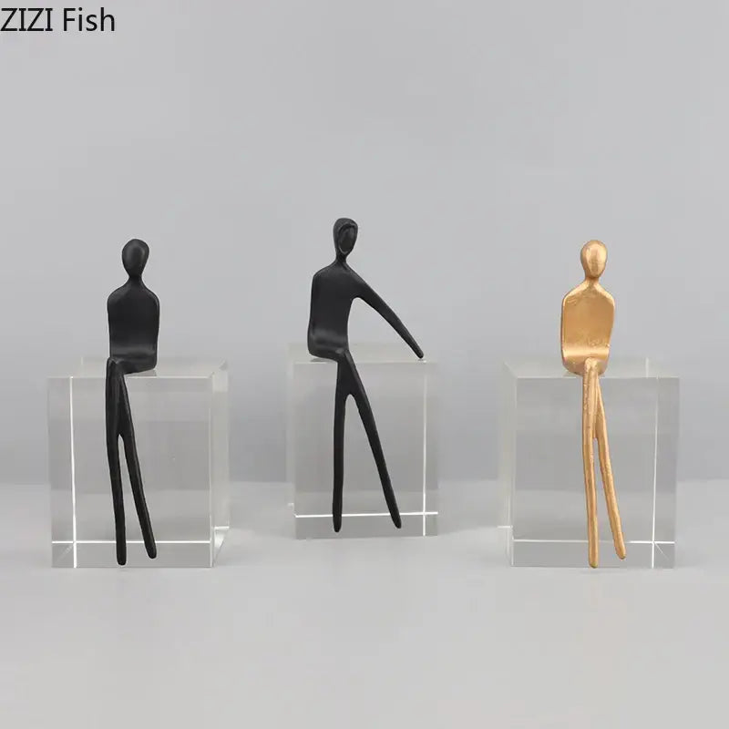 Decorbites abstract character sculpture with three black and gold figurines seated on a crystal base for modern decor
