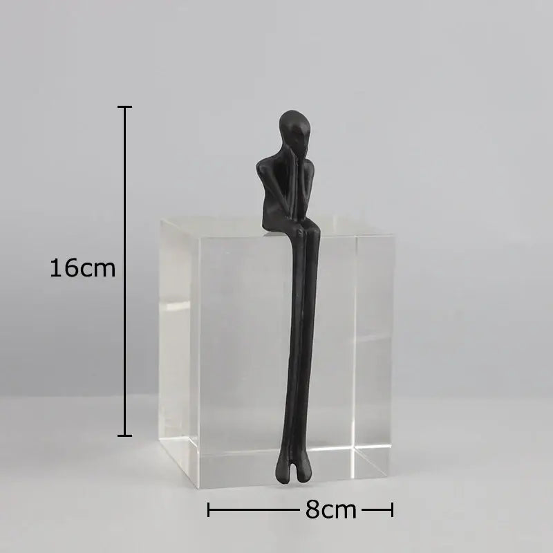 Black matte decorbites abstract character sculpture with elongated limbs on a clear crystal base for modern decor