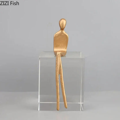 Gold-colored decorbites abstract character sculpture with crystal base featuring elongated legs for modern room decor