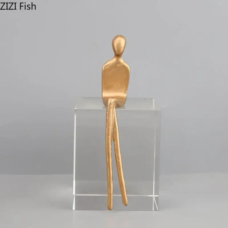 Gold-colored decorbites abstract character sculpture with crystal base featuring elongated legs for modern room decor