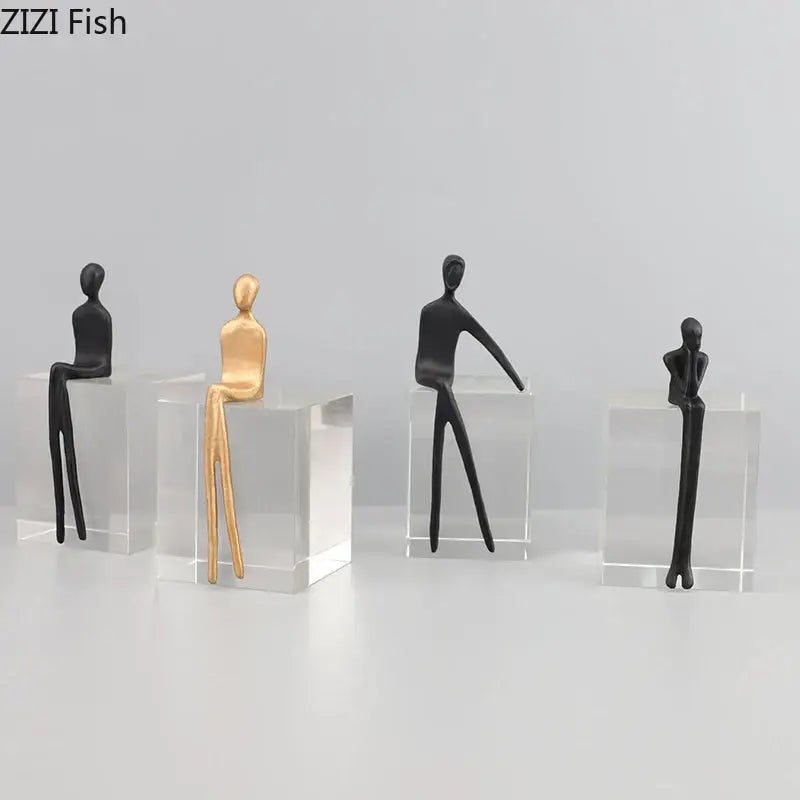Minimalist decorbites abstract character sculpture in black and gold seated on a clear crystal base for modern decor