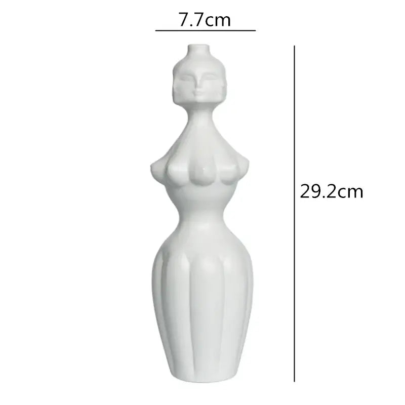 A sleek white ceramic vase shaped like a stylized female figure with sculpted contours decorbites abstract character