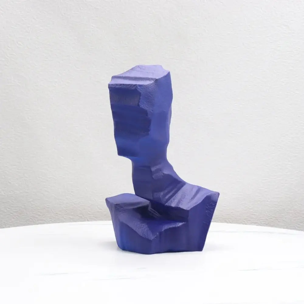 A bold cobalt blue decorbites abstract characters sculpture with angular blocky forms for modern living room decor