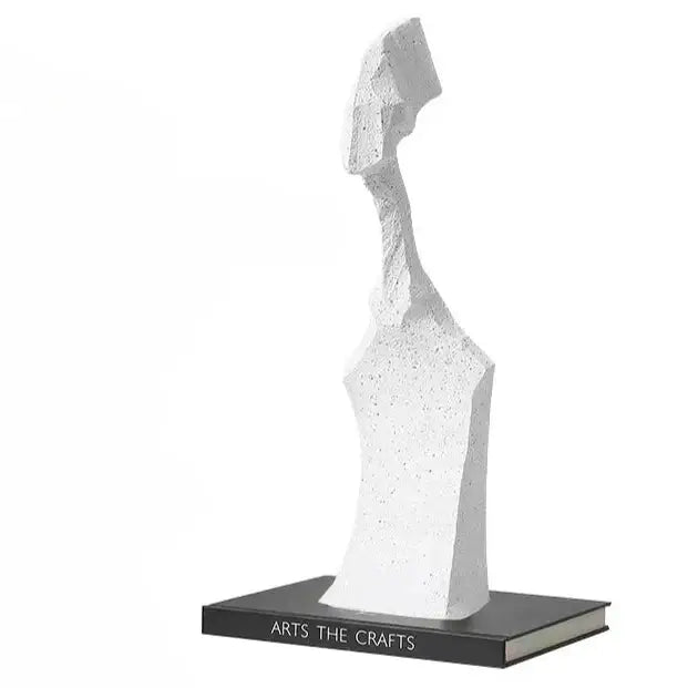White decorbites abstract characters sculpture with textured speckled surface on black book base for modern decor