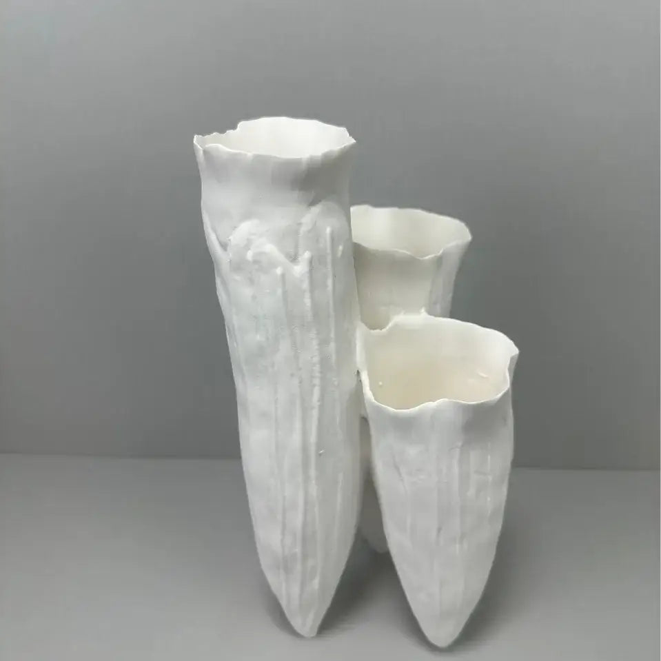 Three white ceramic vases with textured surfaces and flared rims in decorbites abstract coral reef design