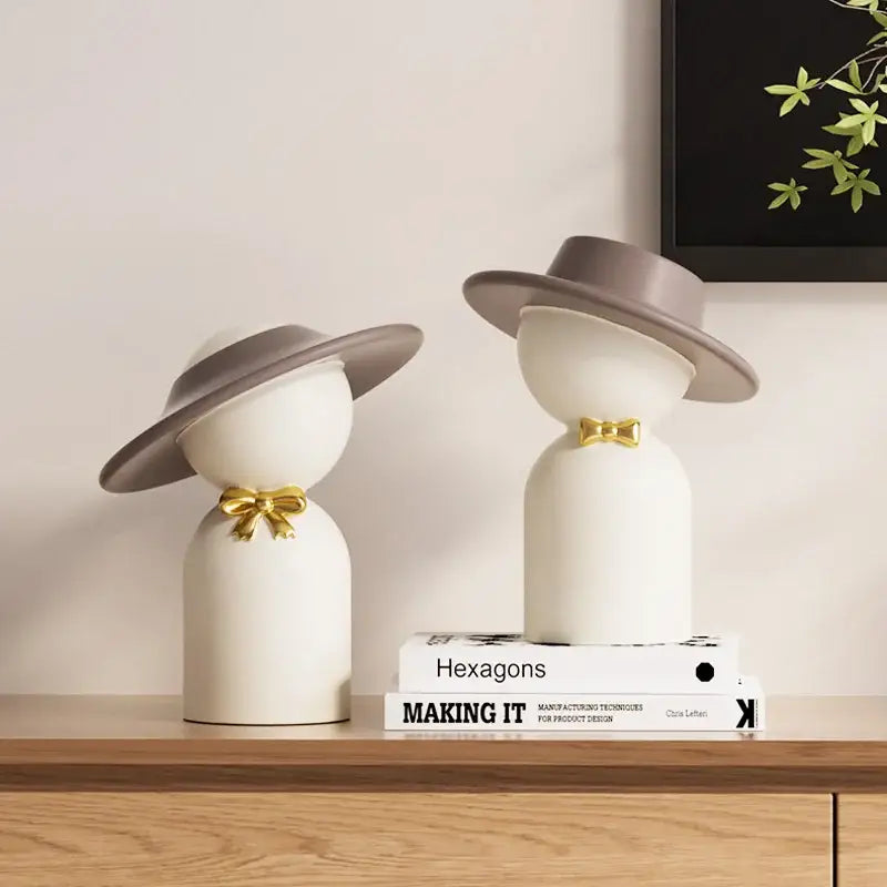 Decorbites abstract couple bust sculpture featuring white ceramic figurines with gray hats and gold bow ties for decor