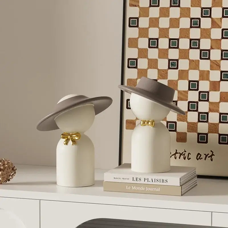DecorBites abstract couple bust sculpture features two minimalist white ceramic figurines with gray hats and gold bow ties