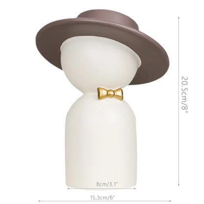 A sleek white ceramic decorbites abstract couple bust sculpture featuring a man with a brown top hat and gold bow tie