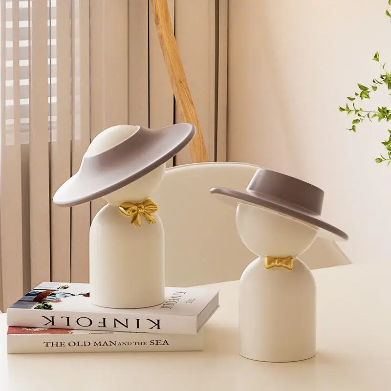 Cream-colored ceramic decorbites abstract couple bust sculpture with gray hats and gold bow ties for modern decor